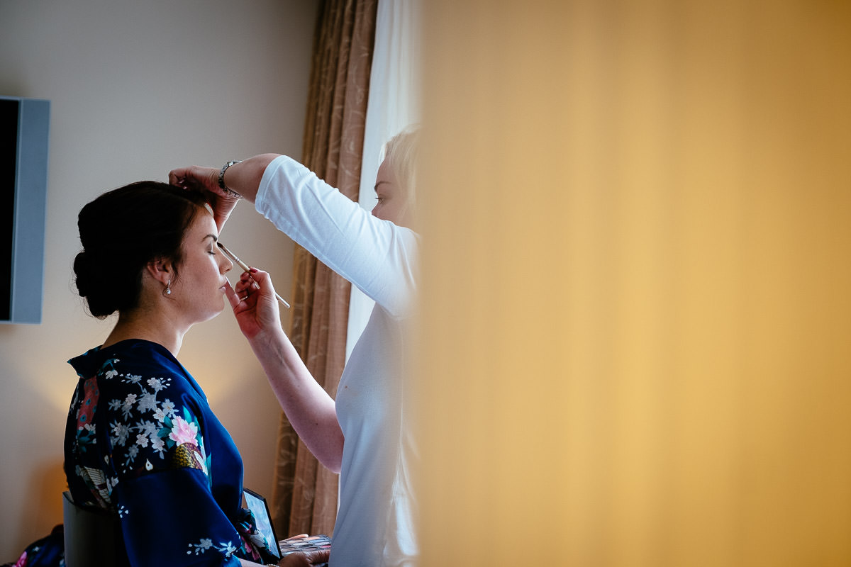 A makeup artist applies eyeshadow to the bride during preparations at Carton House.