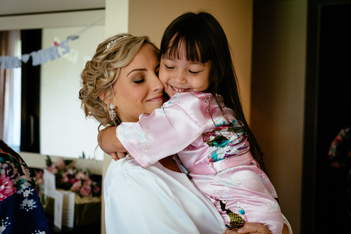 The bride shares a hug with a young flower girl during preparations at Carton House.