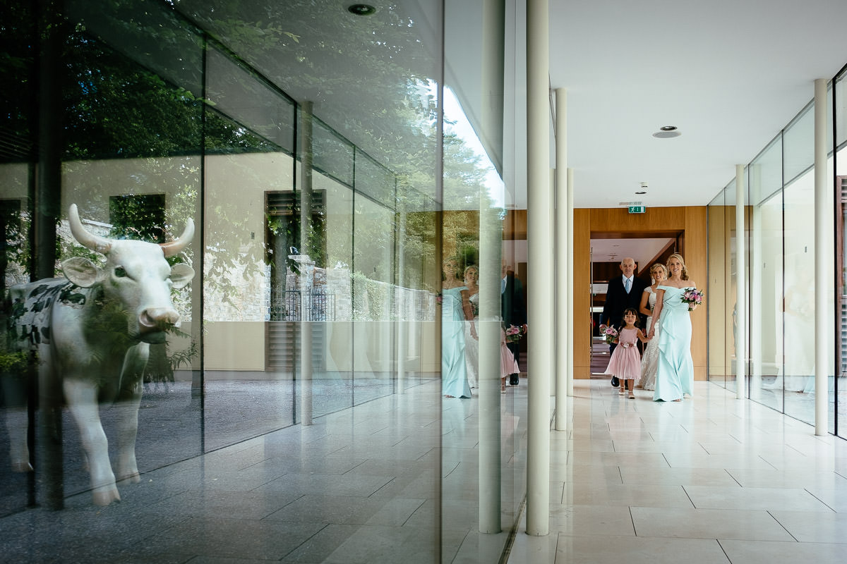 Bridesmaids and family arrive through a glass corridor at Carton House ahead of the ceremony.