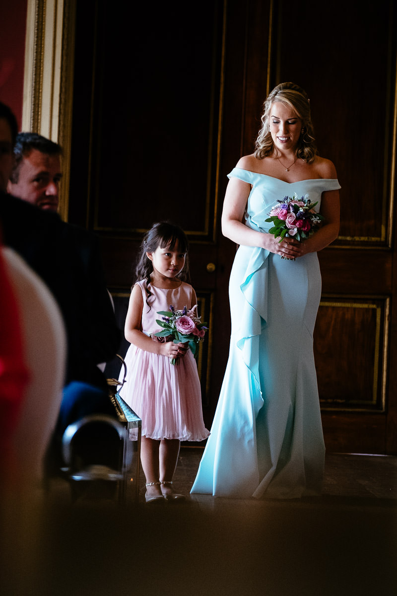 A bridesmaid and flower girl wait together before the ceremony begins at Carton House.