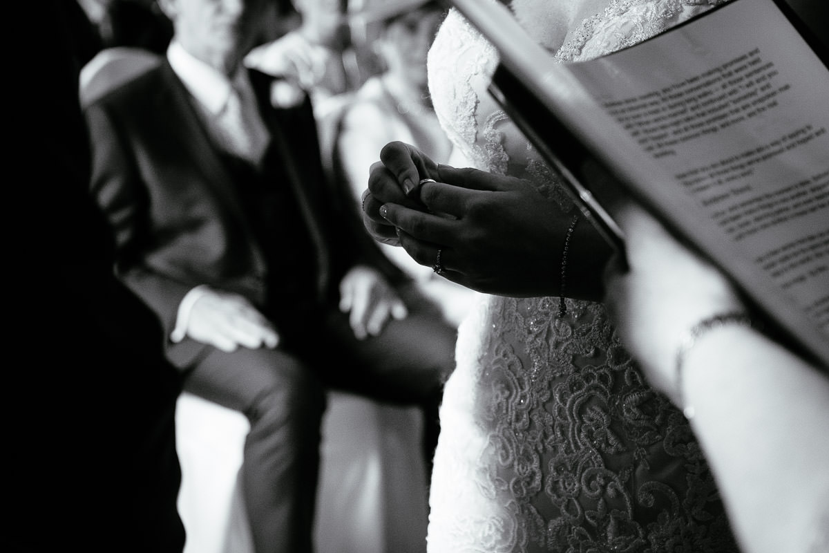 Close-up of the bride's hands holding her order of service during the ceremony at Carton House.