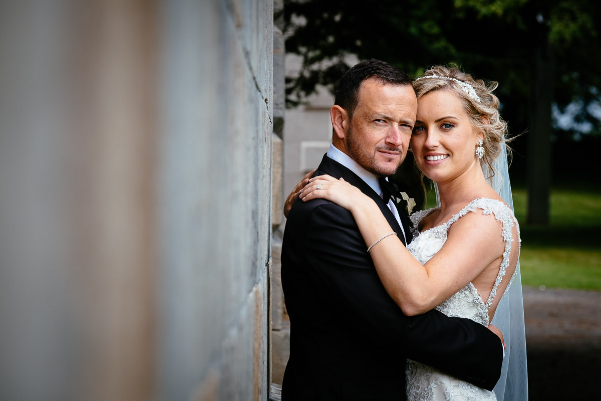 The bride and groom share a close embrace outdoors at Carton House.