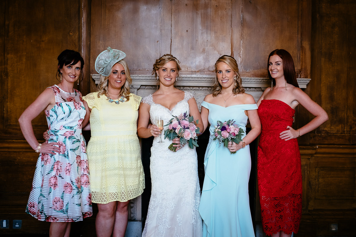 The bride poses with her bridesmaids against a wood-panelled wall at Carton House.
