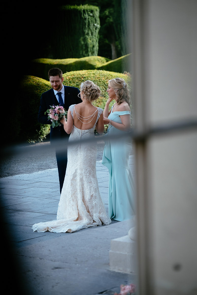 The bride and groom chat with a bridesmaid outside at Carton House.