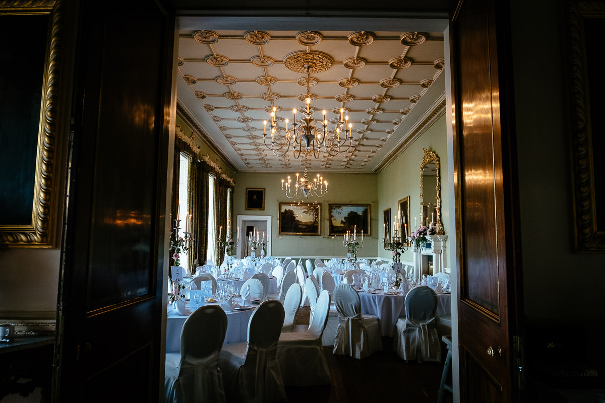 A grand dining room set up for the wedding reception, seen through open doors at Carton House.