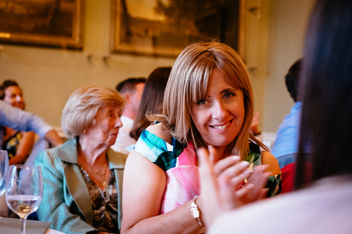 A guest smiles and claps during the wedding speeches at Carton House.