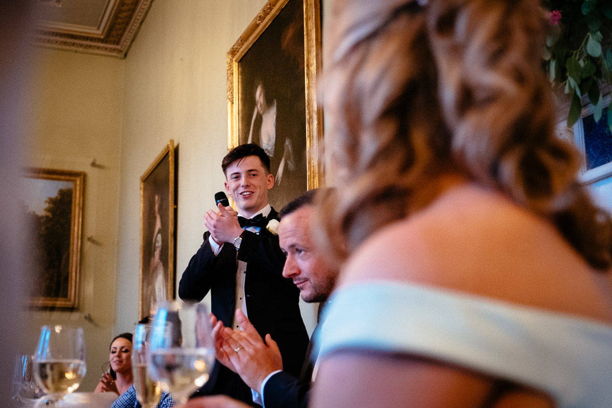 The best man gives a speech as the groom claps beside him at Carton House.