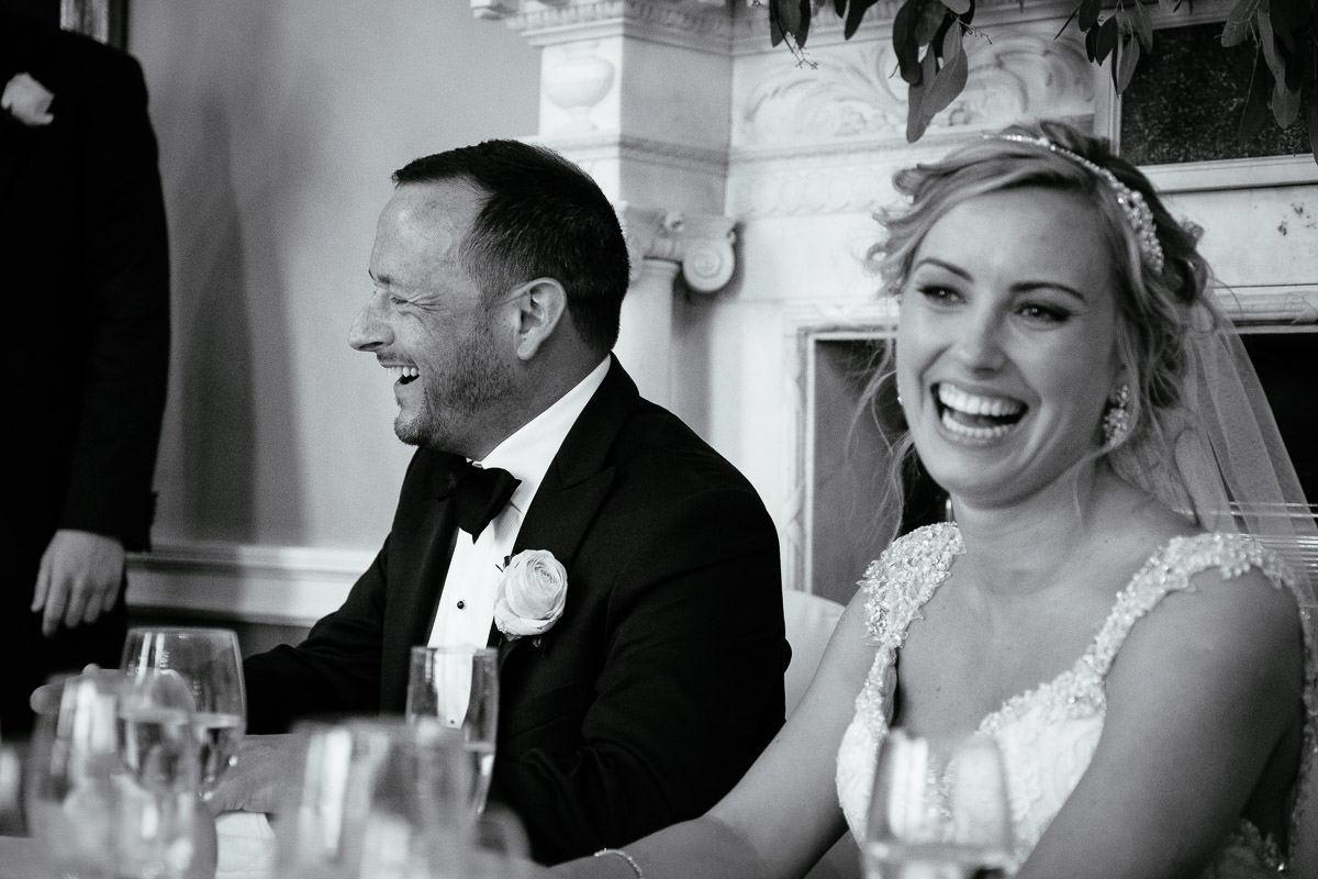 The bride and groom laugh together during the speeches at Carton House.
