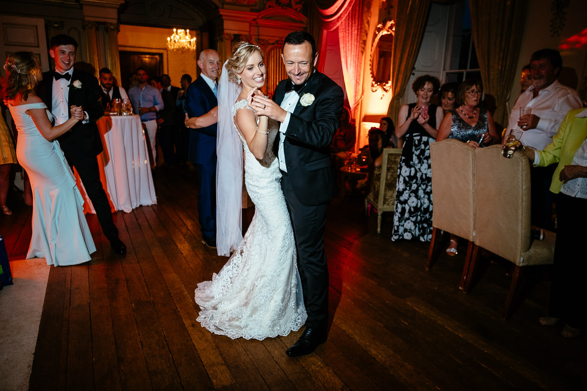 Guests clap as the bride and groom dance together at Carton House.