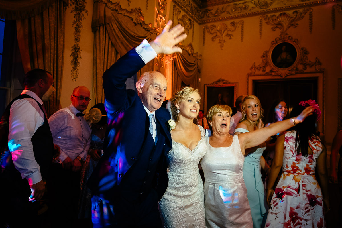 The bride celebrates with her father and mother on the dance floor at Carton House.
