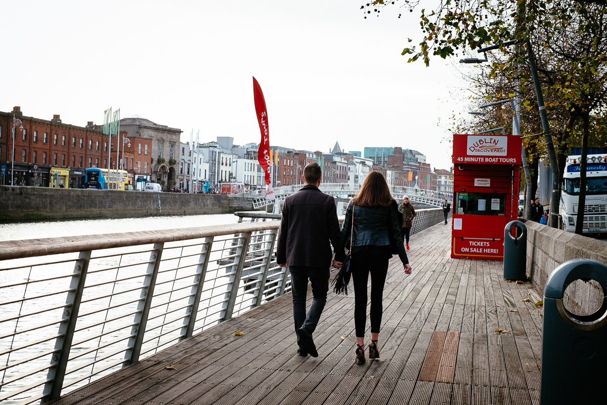couple walking along the river liffey boardwalk in dublin