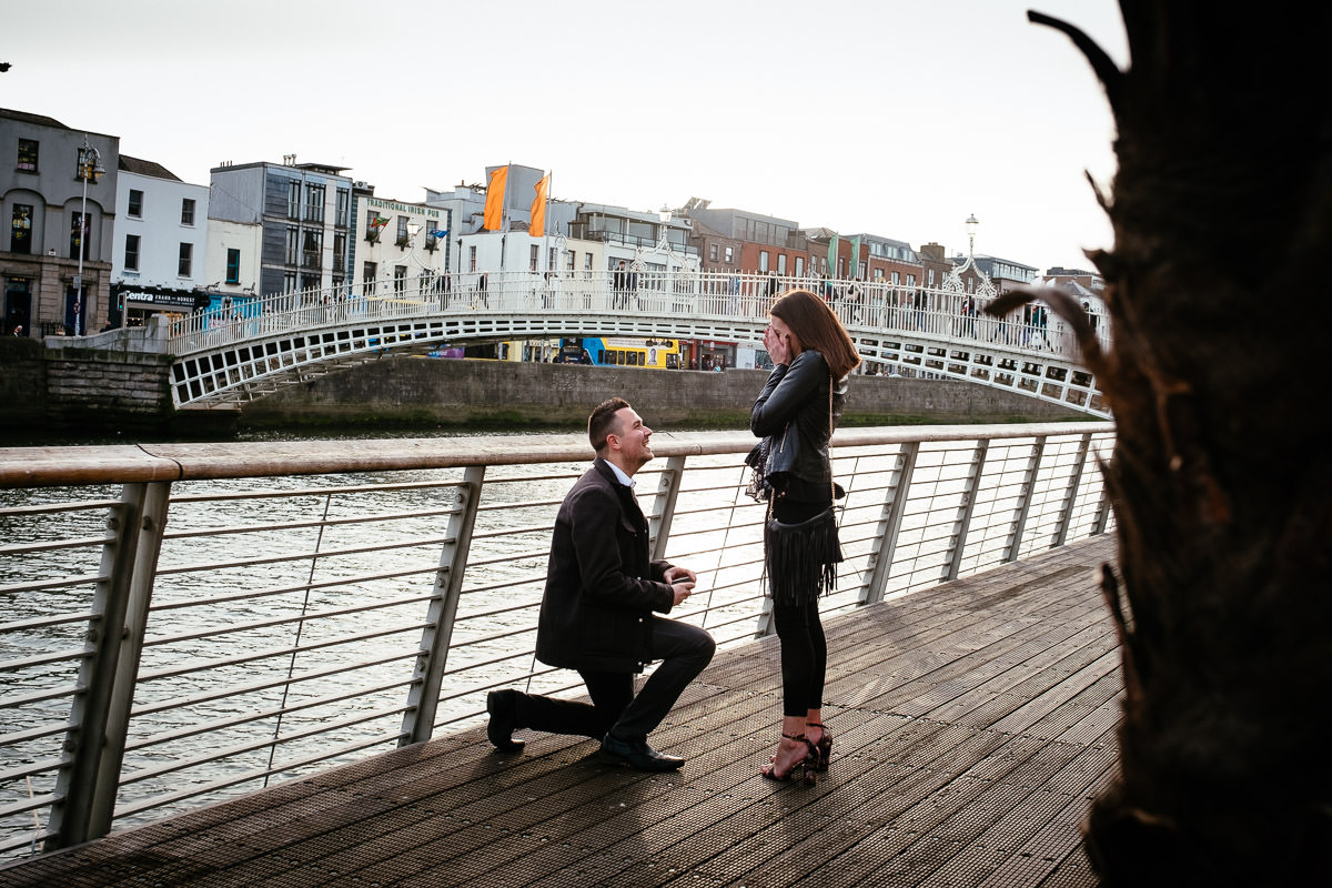 guy proposing to his girlfriend by the river liffey boardwalk in dublin