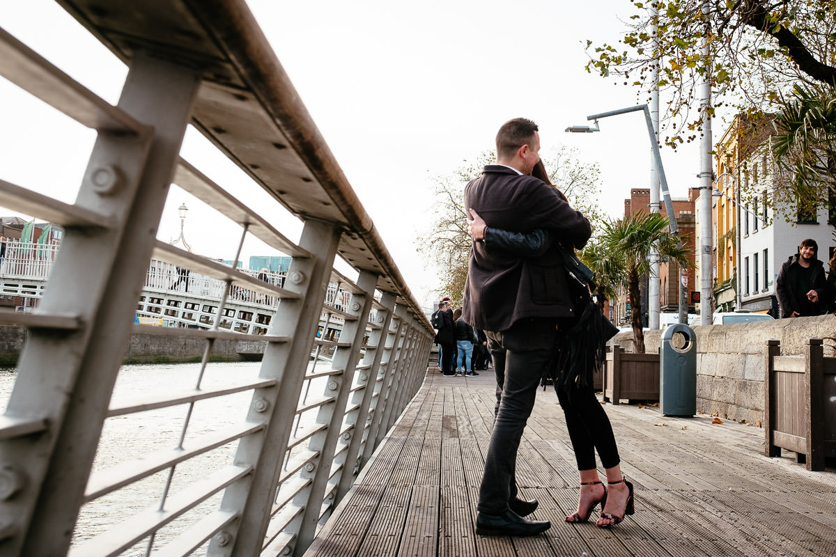 guy proposing to his girlfriend by the river liffey boardwalk in dublin