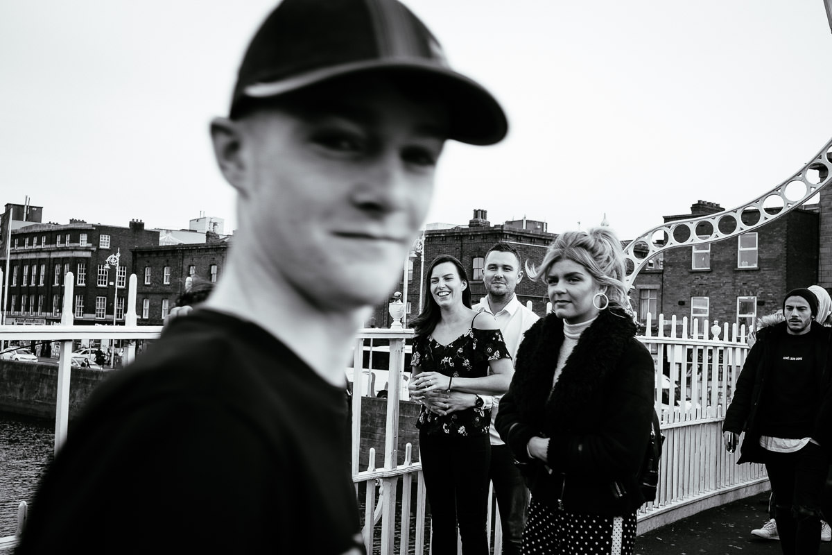 newly engaged couple with a pedestrian on the ha'penny bridge in dublin