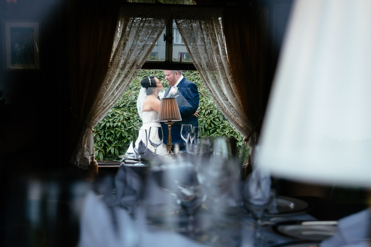 bride and groom kissing through train carriage at glenlo abbey hotel wedding