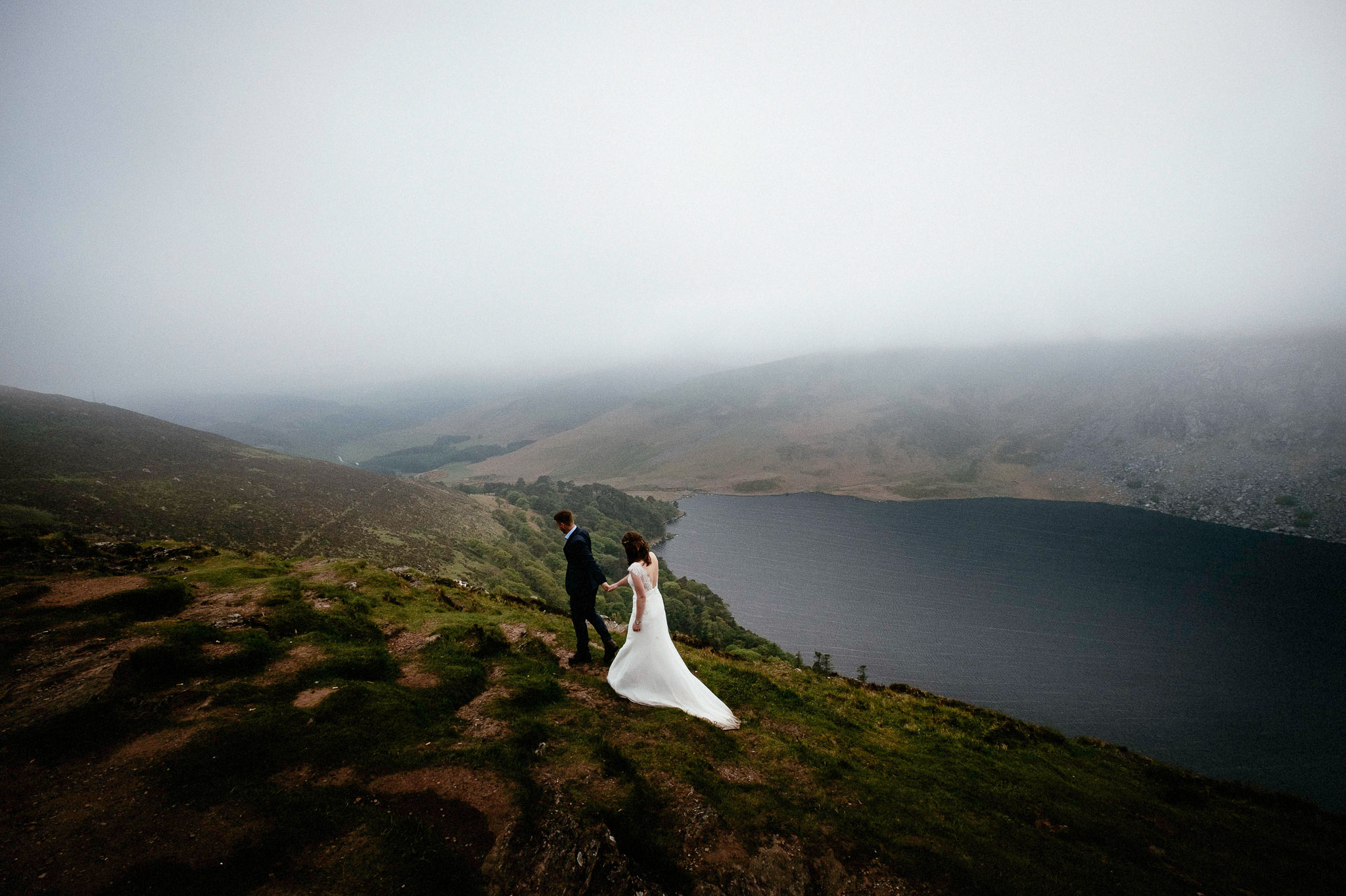 bride and groom walking across mountain in Wicklow, Ireland