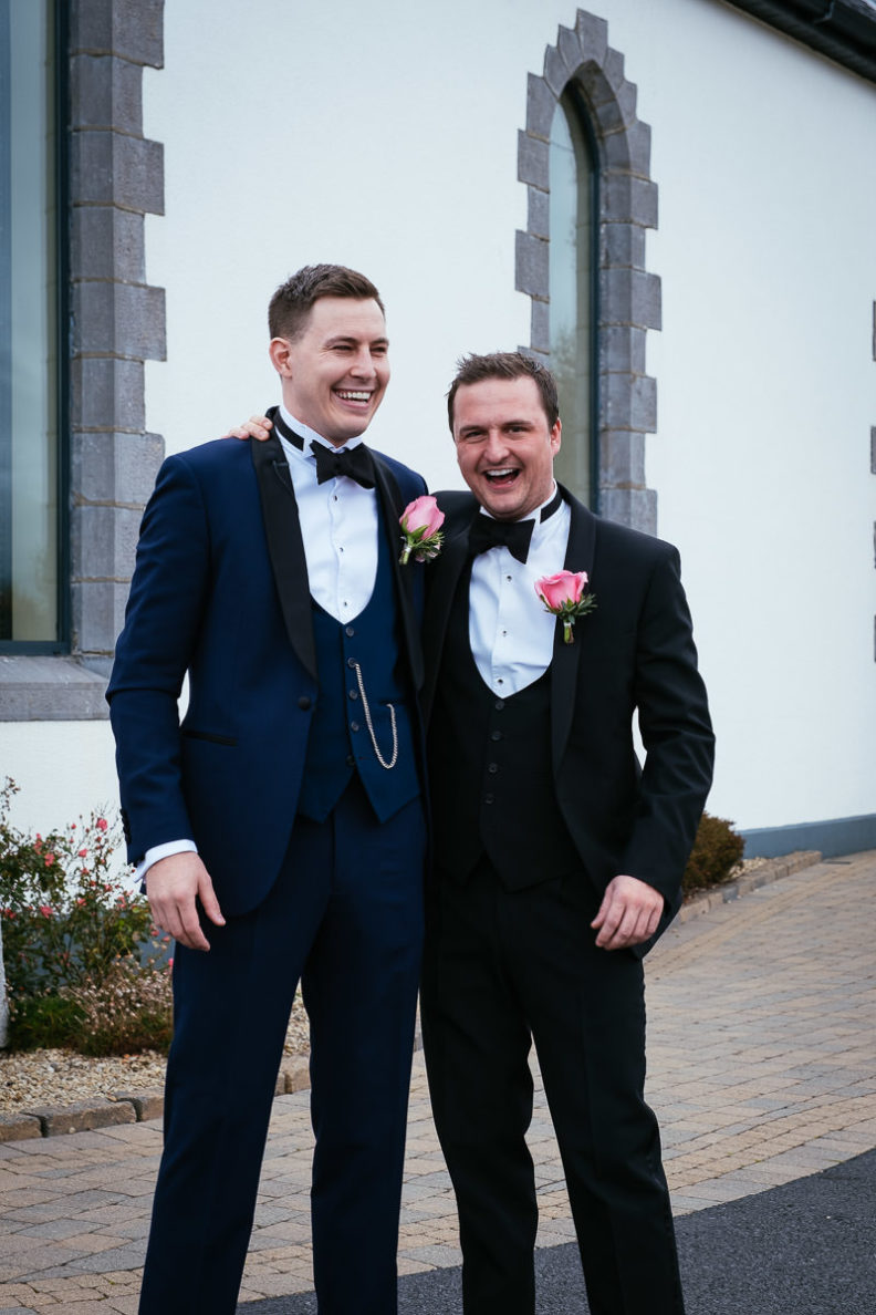 groom and best man laughing outside church