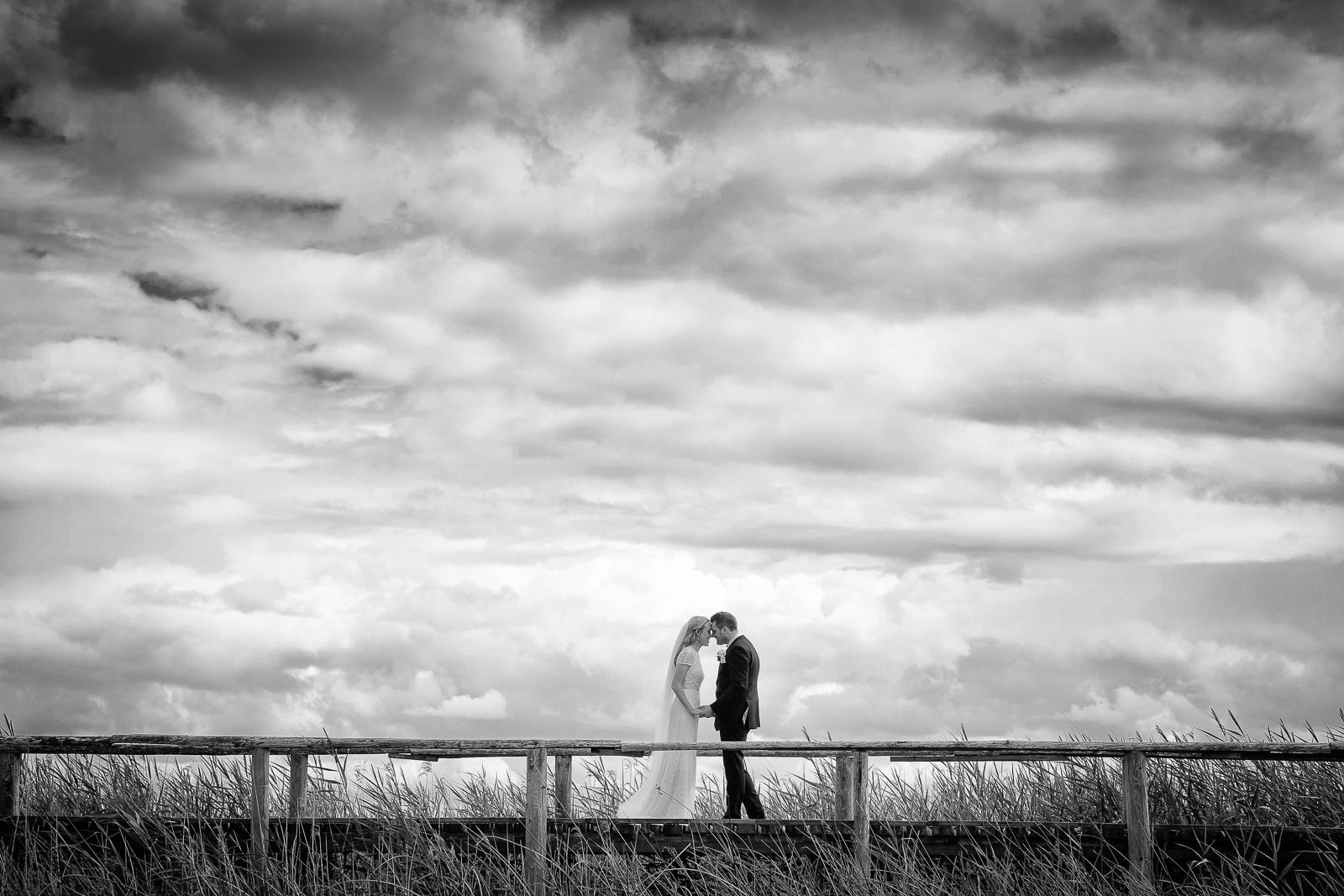 bride and groom standing on a bridge at glasson house athlone