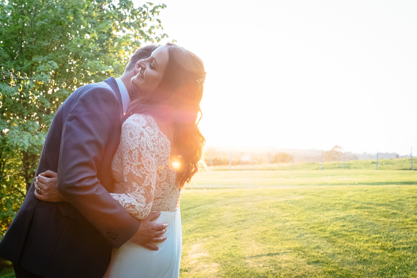 bride and groom hugging at sunset