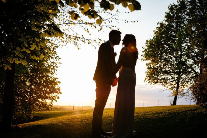 Kilshane House Wedding Photographer 12 bride and groom kissing with the sun setting behind them at their kilshane house wedding in tipperary ireland
