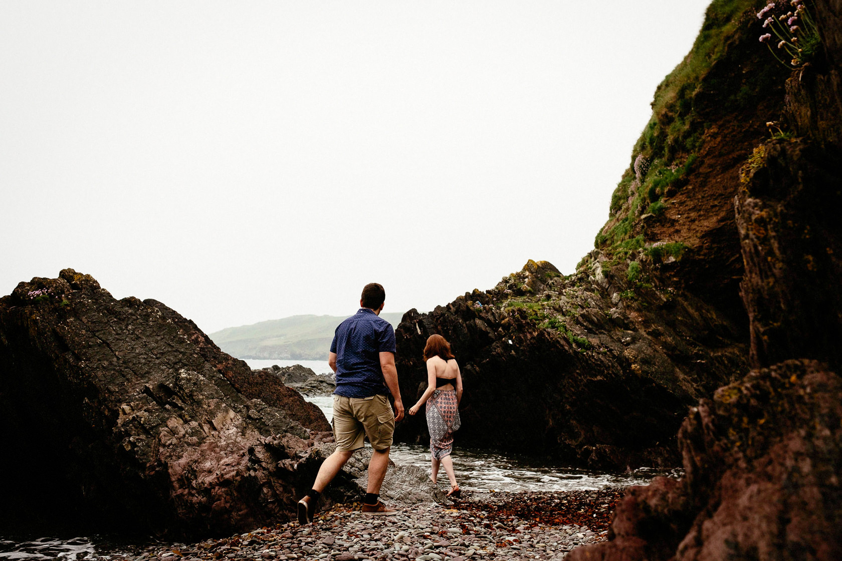 engaged couple walking along a beach in ballycotton county cork ireland