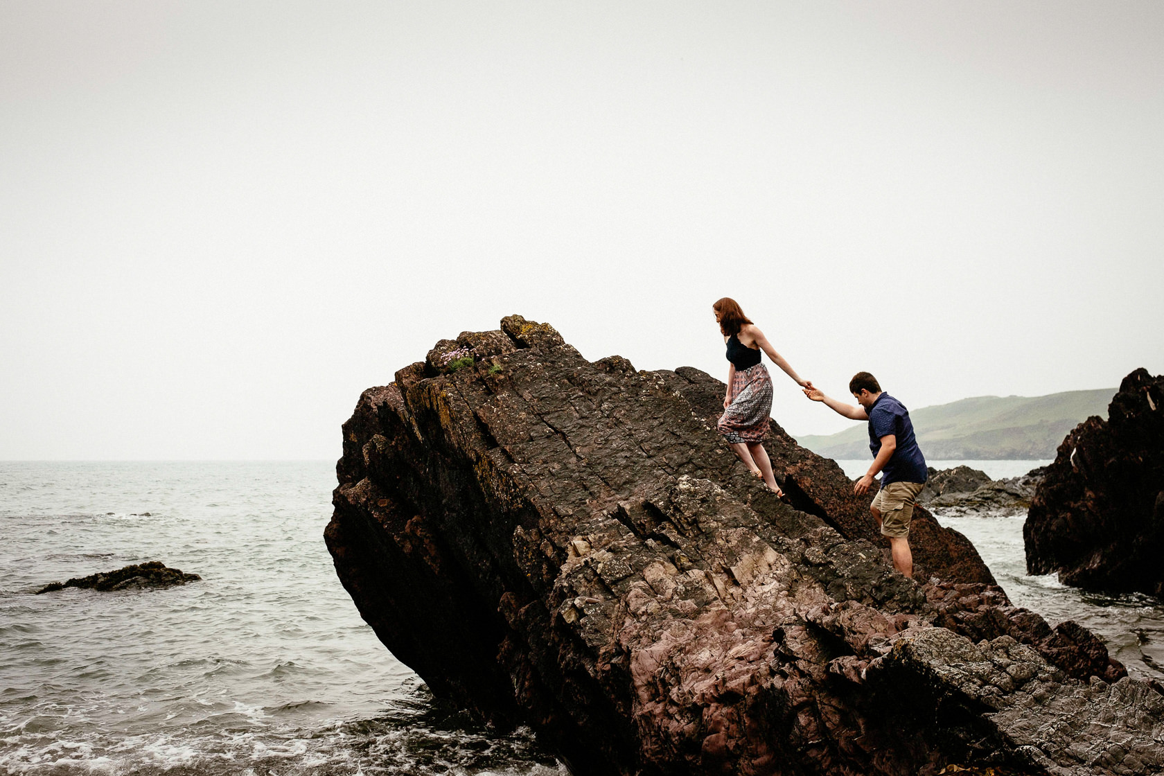 engaged couple walking along a beach in ballycotton county cork ireland