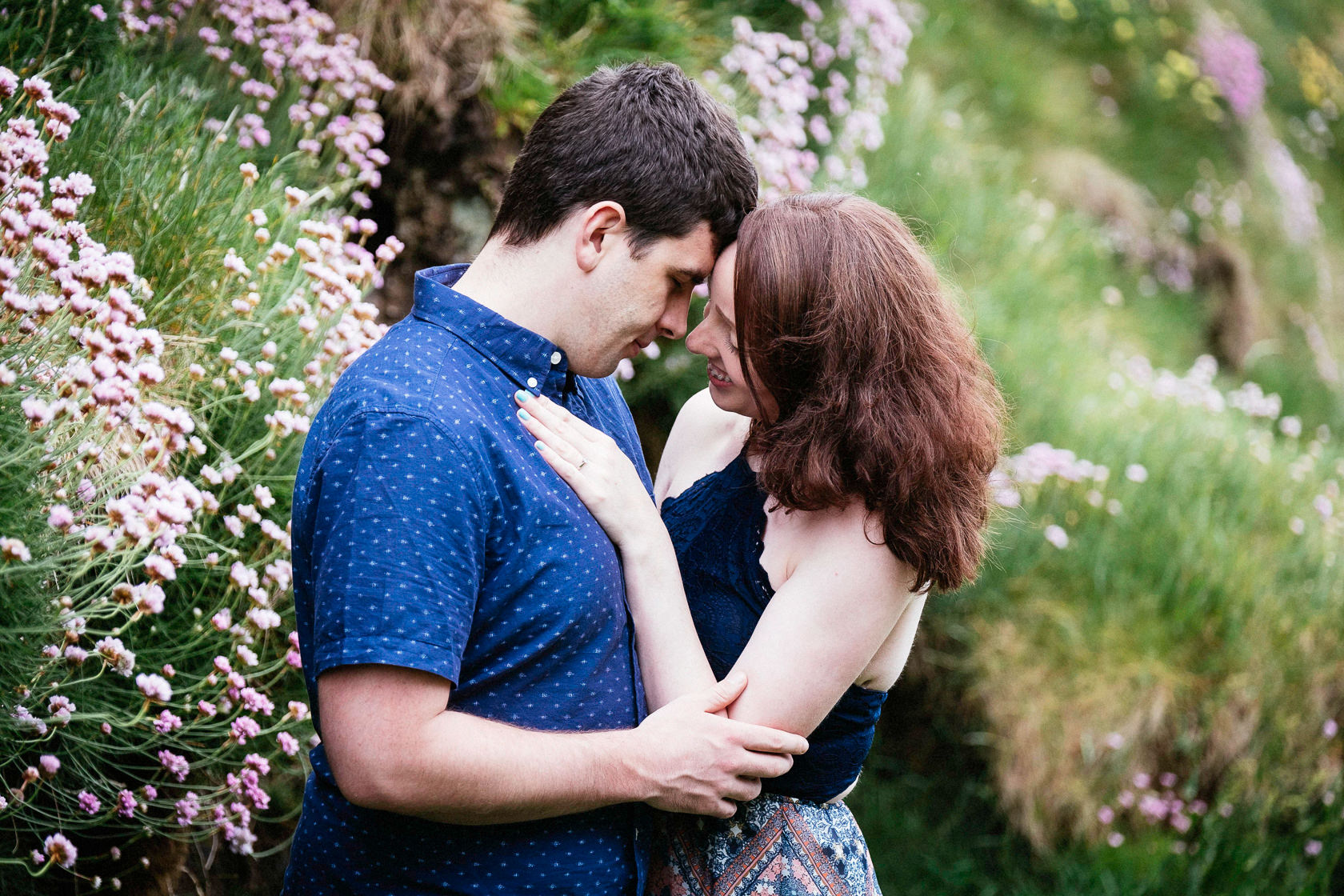 engaged couple embracing on a cliff in ballycotton county cork ireland