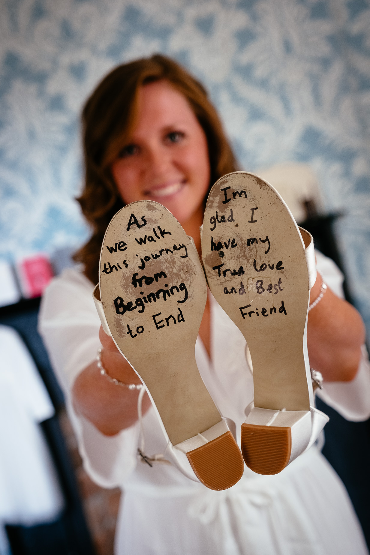 bride holding her wedding shoes