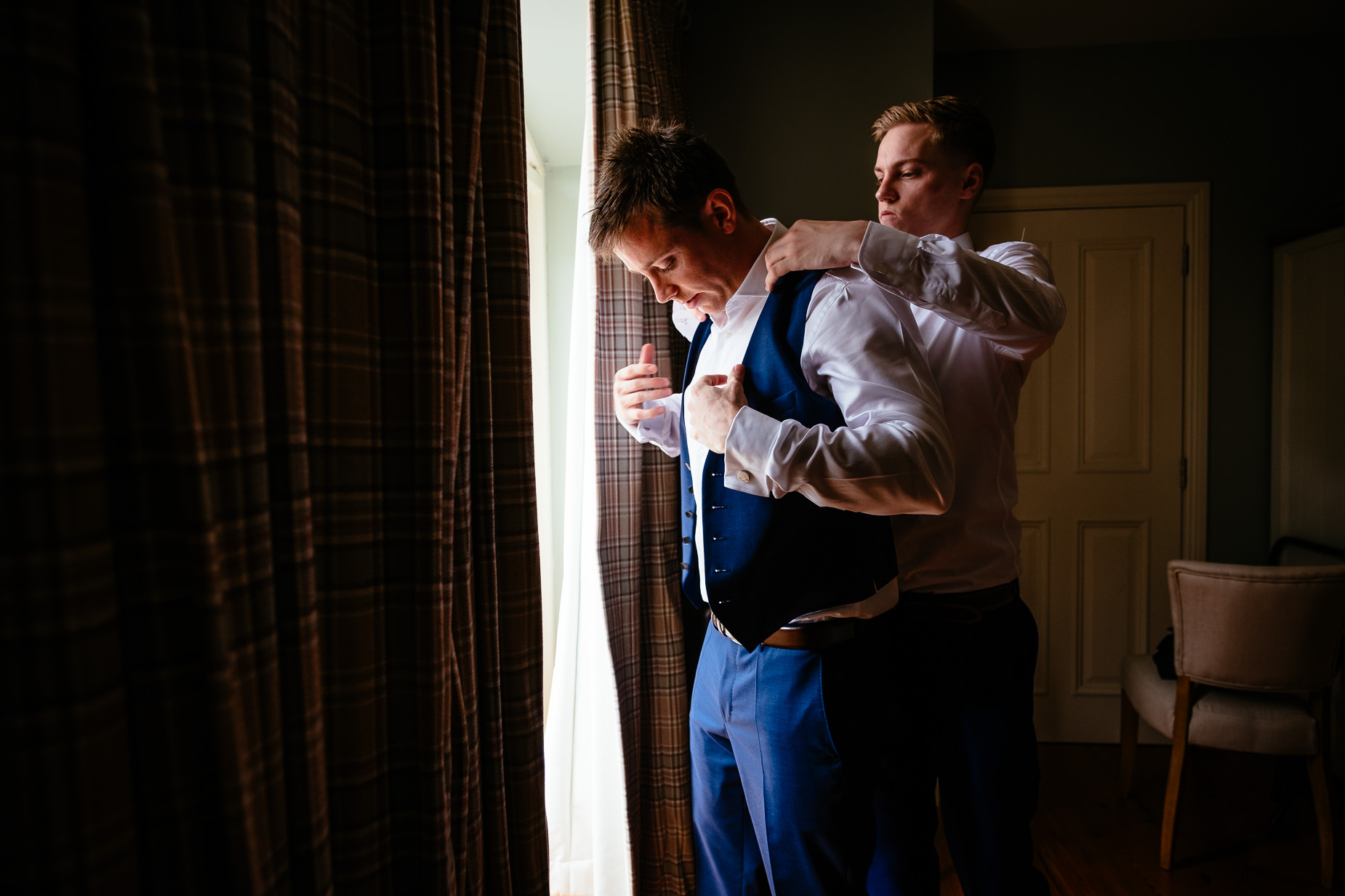 groom putting his waistcoat on
