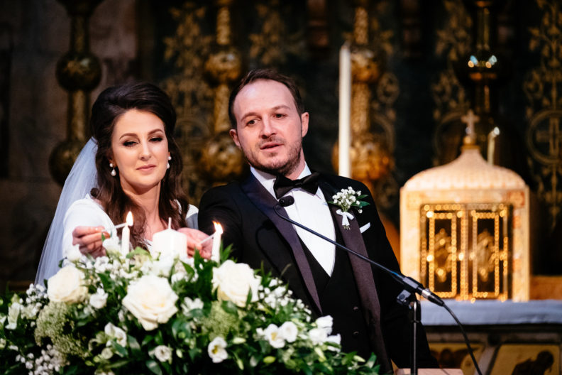 bride and groom lighting a candle on the alter