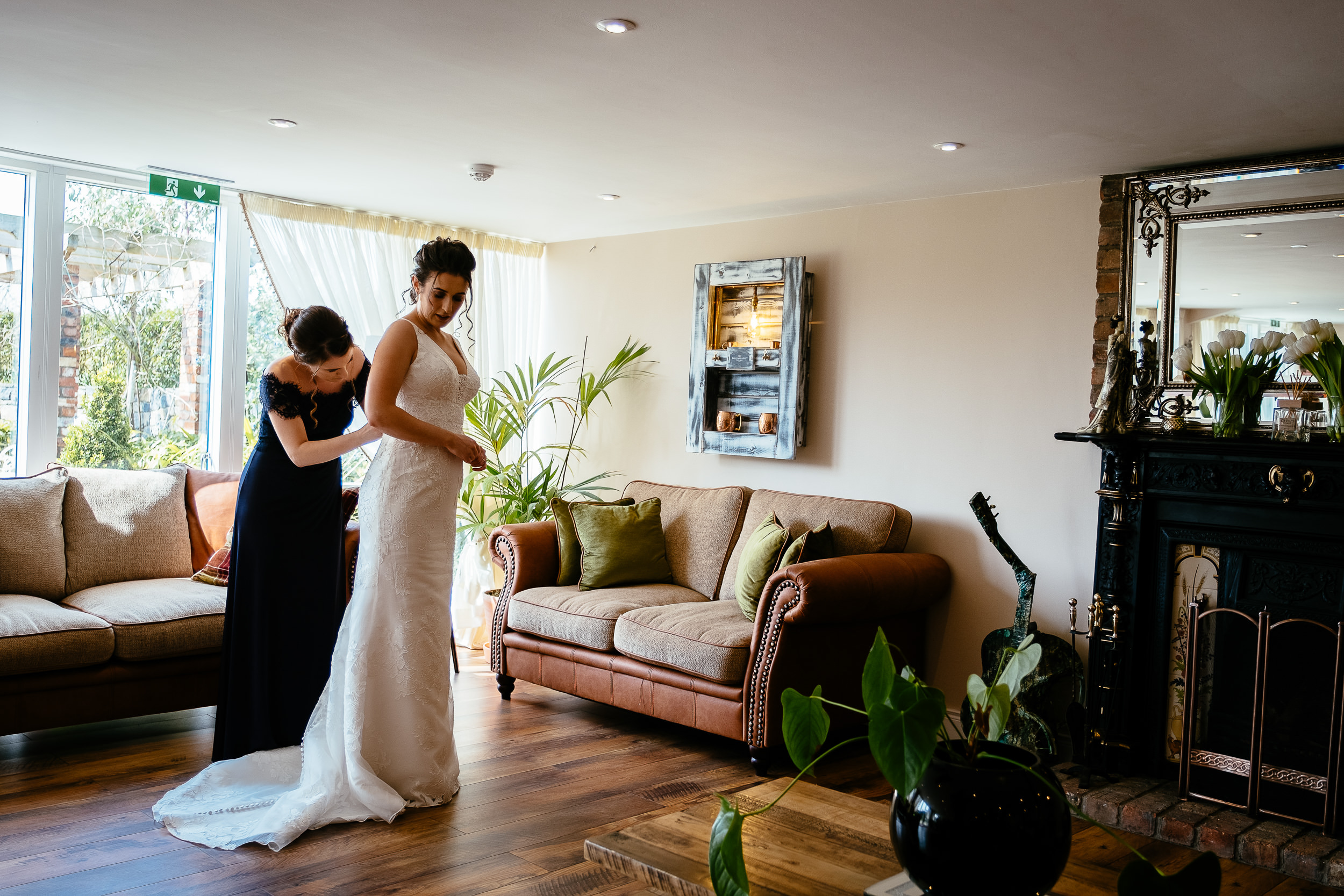 bride being helped into her dress at ballymagarvey village