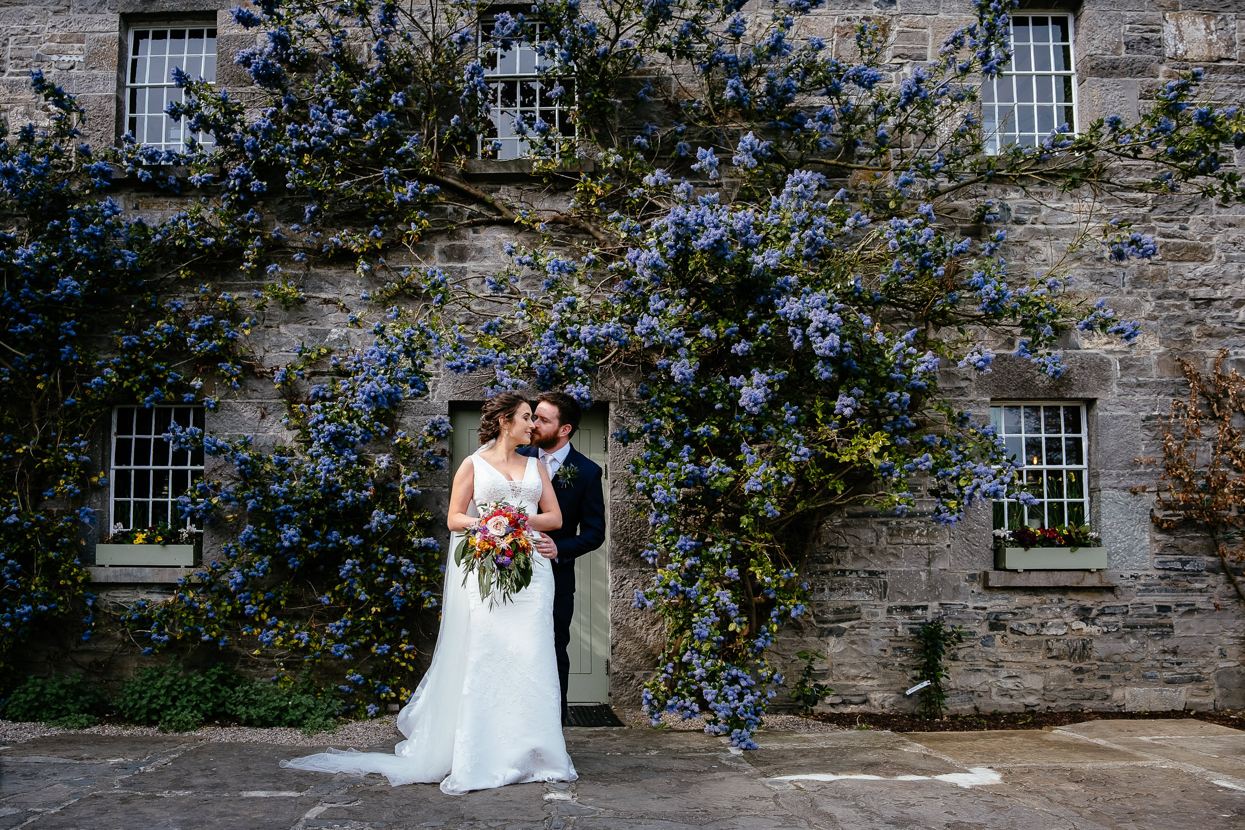 bride and groom embracing in front of doorway at Ballymagarvey village meath