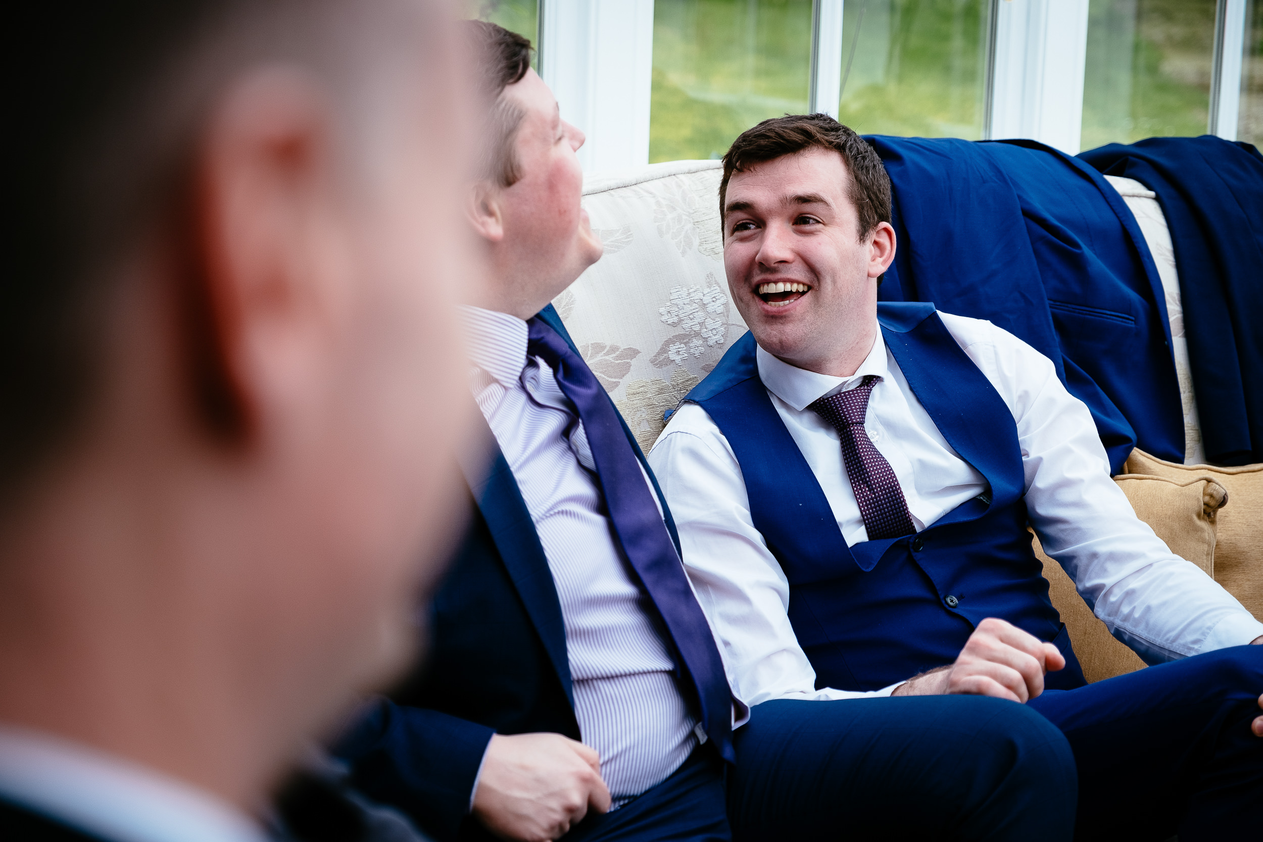 two male wedding guests laughing