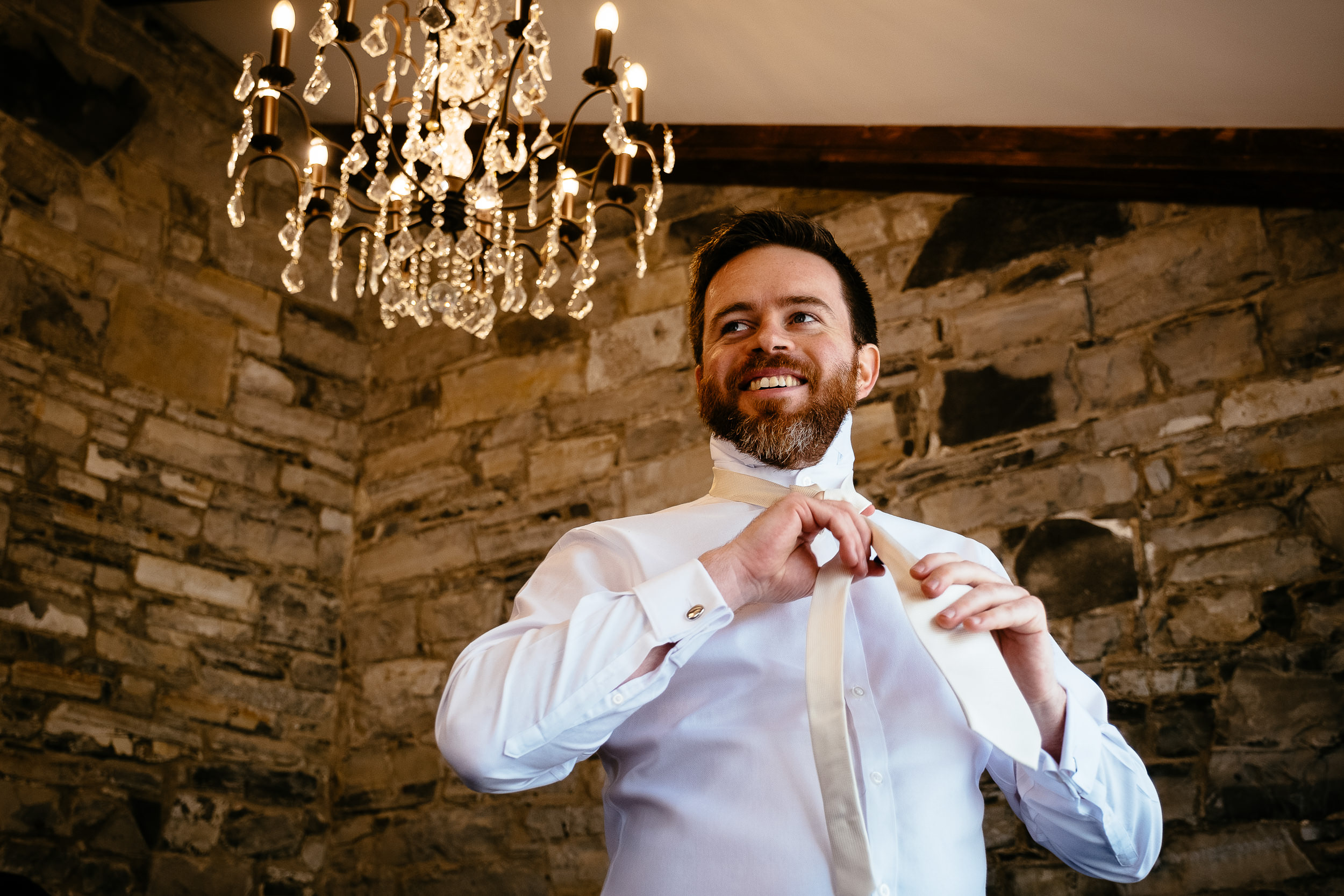 groom putting on a tie
