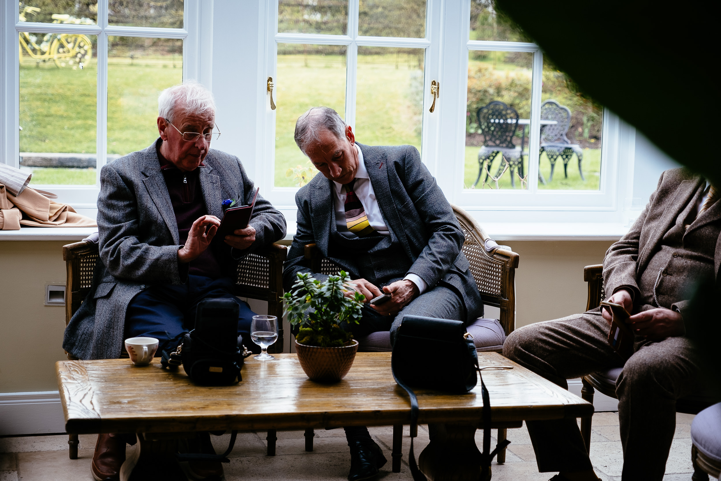 two old men checking their mobile phones