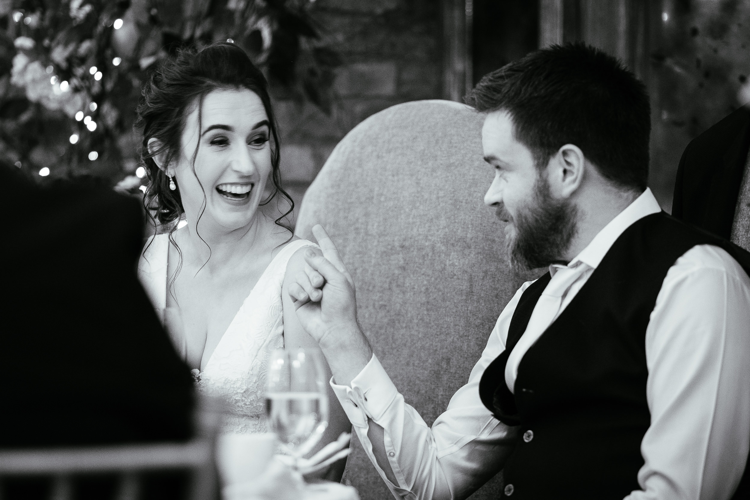 bride and groom laughing at dinner table