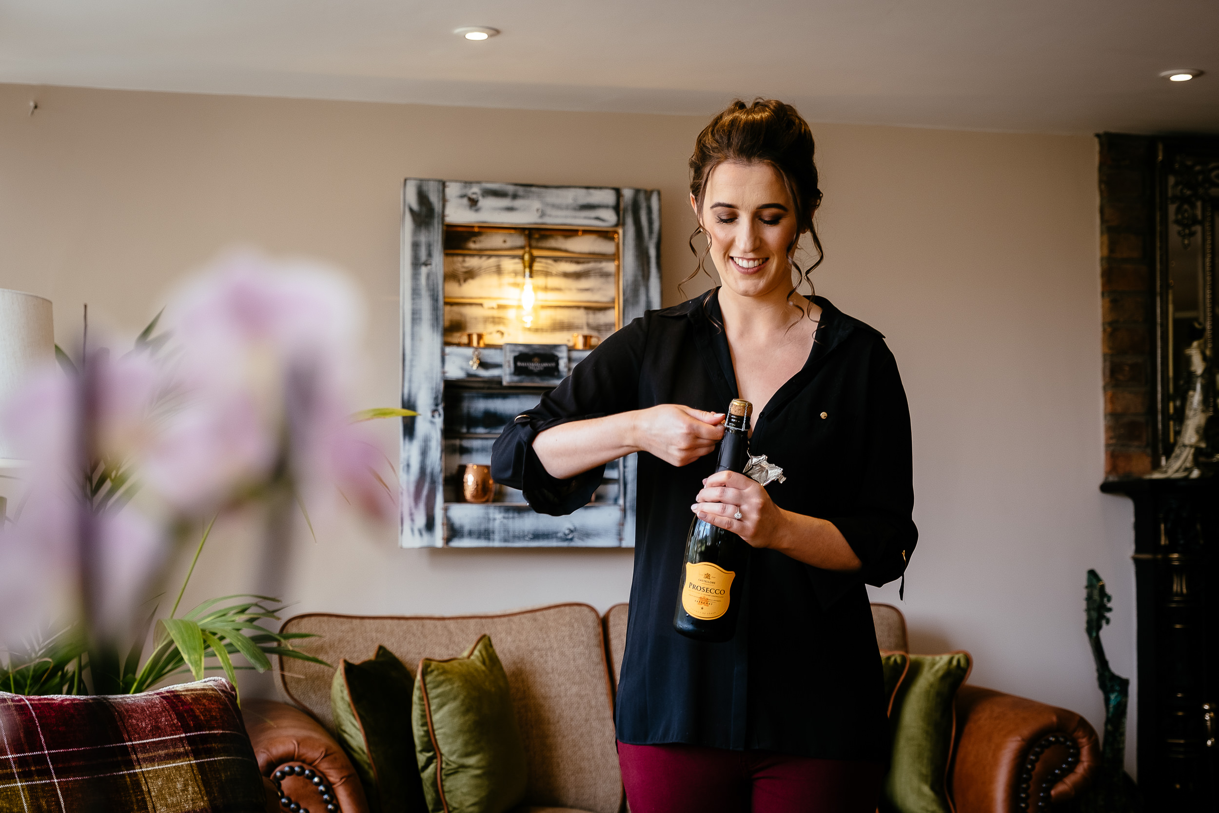 bride opening a bottle of champagne at Ballymagarvey village meath