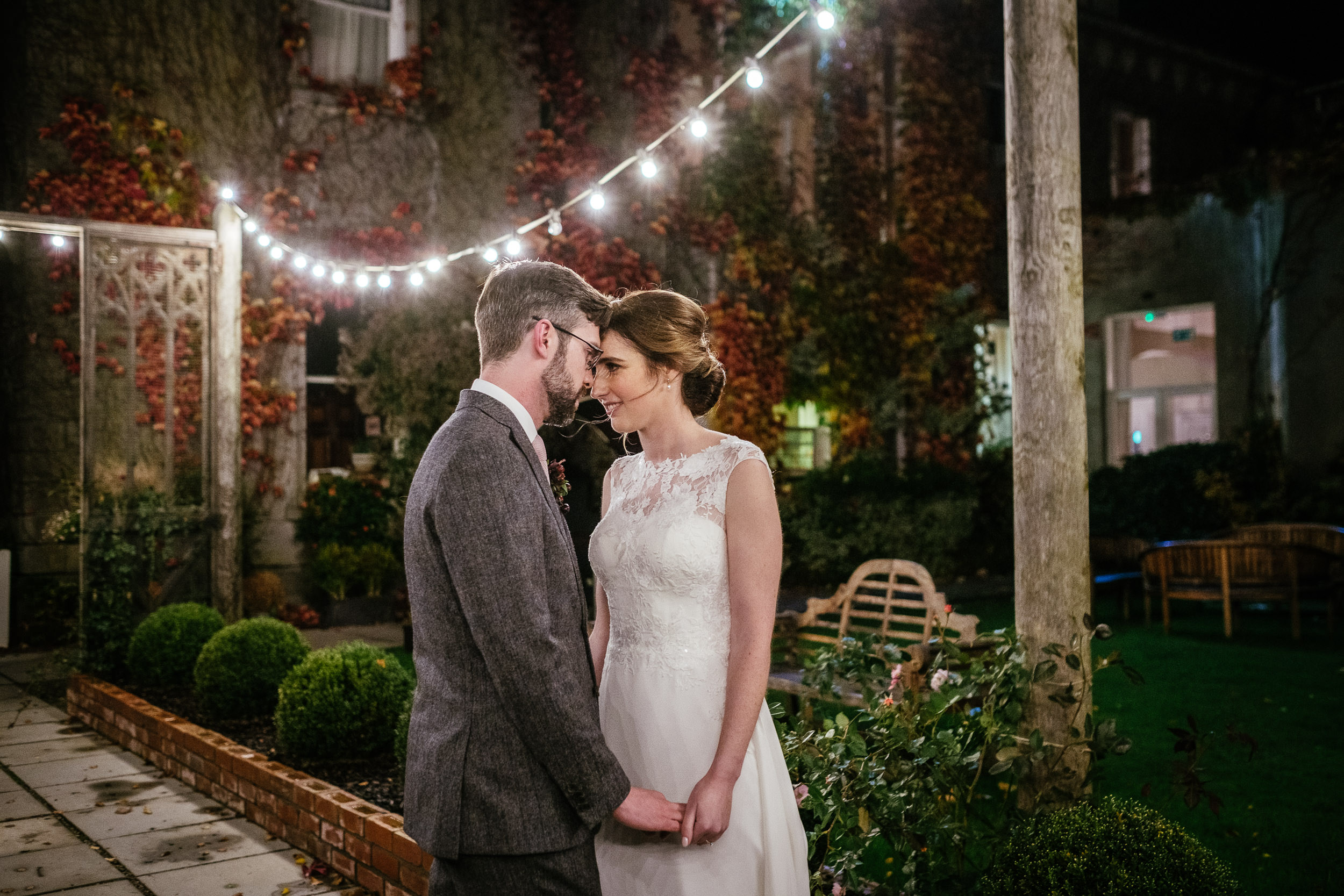 bride and groom hugging under the outdoor fairy lights during their Autumn Wedding at Tinakilly House