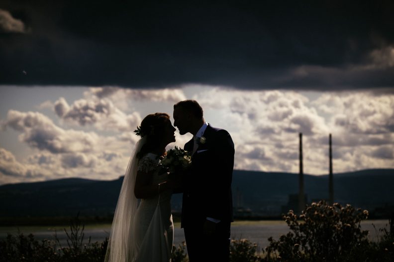 bride and groom with ringsend and Dublin skyline in background
