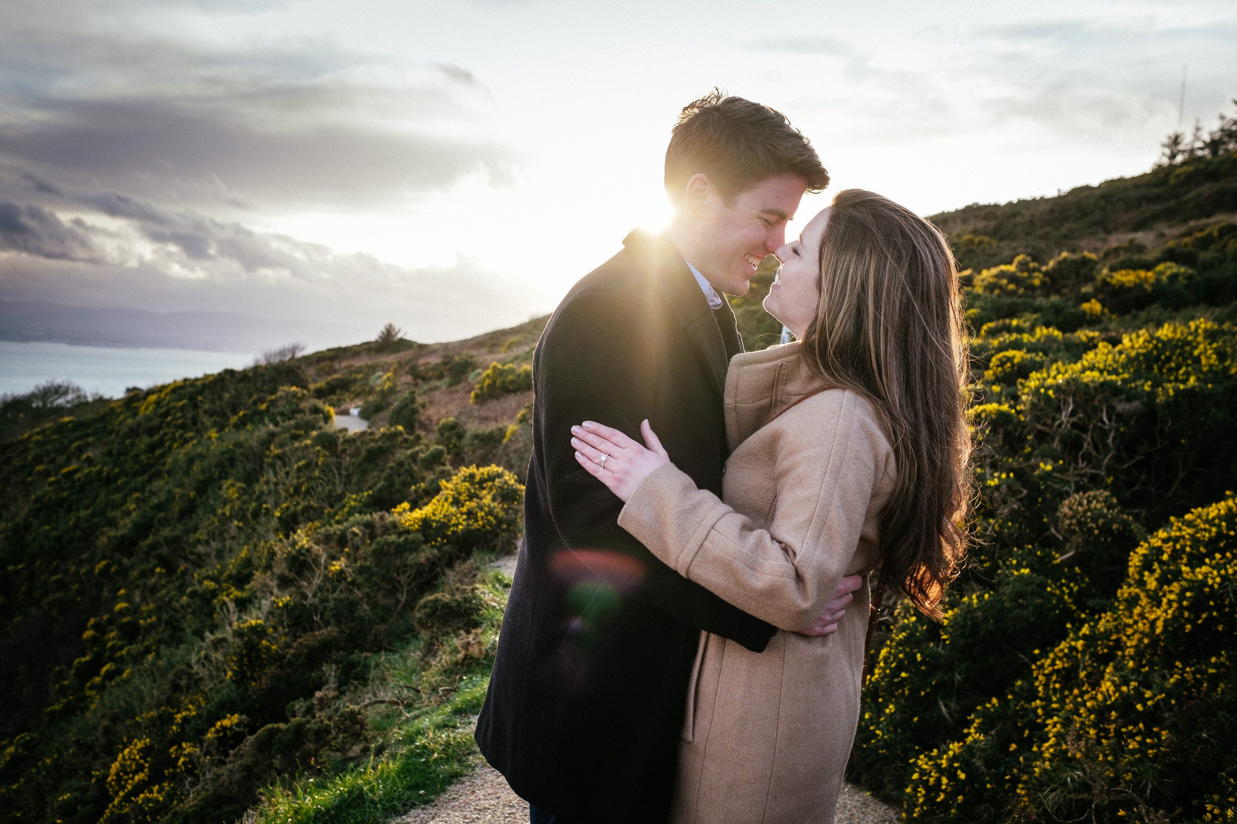 engaged couple kissing on the cliff path at howth summit dublin