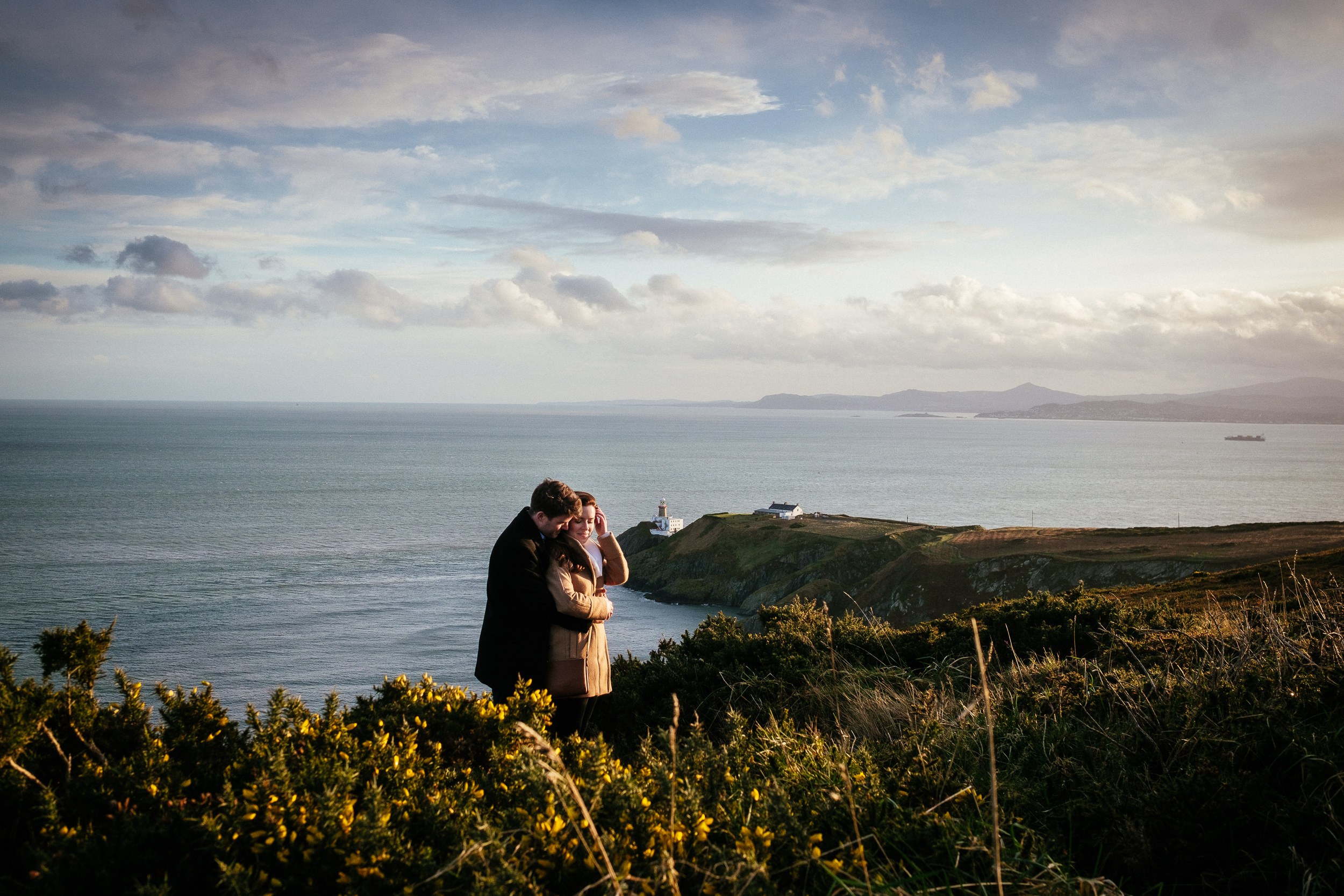 engaged couple hugging on the cliff path at howth summit dublin