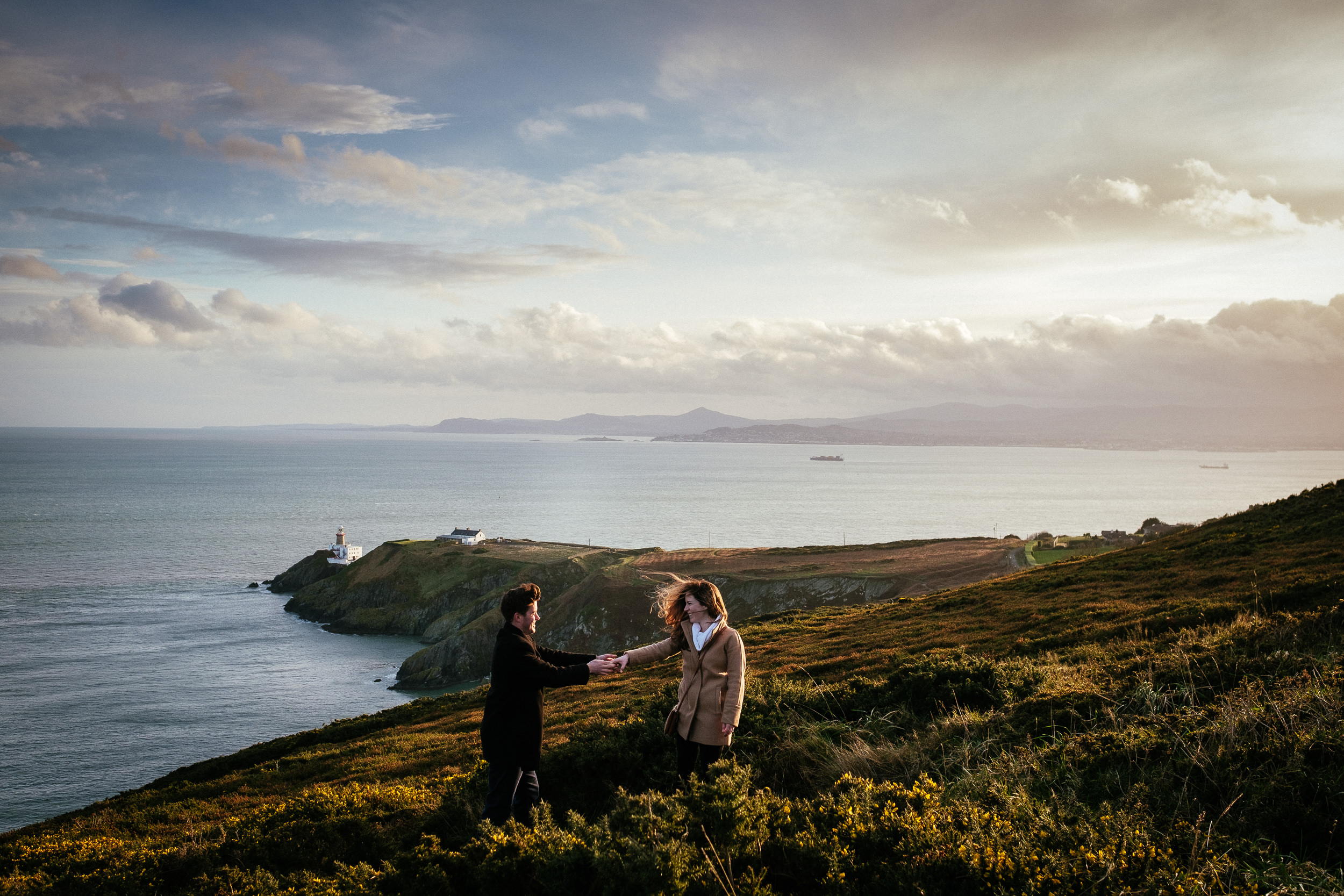 engaged couple dancing on the cliff path at howth summit dublin