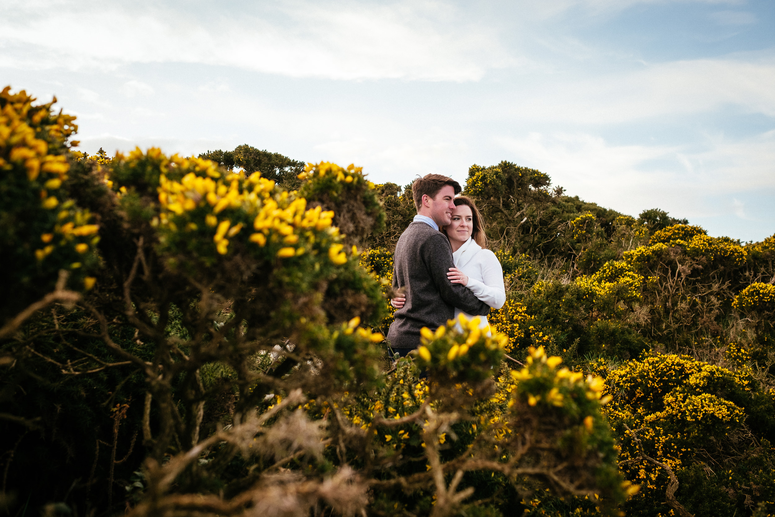 engaged couple embracing after proposing at Howth Head Dublin