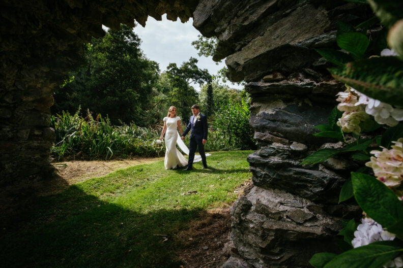 bride and groom walking through arch at wedding in Druids Glen Hotel Wicklow