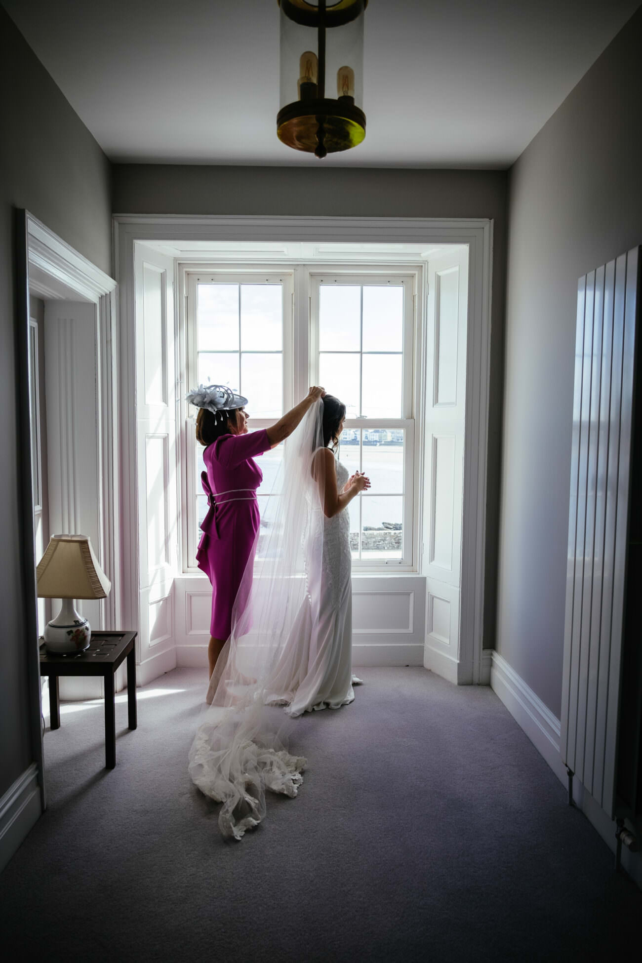 A bride is getting ready in a room at the Trump International Hotel Doonbeg, overlooking a picturesque window.