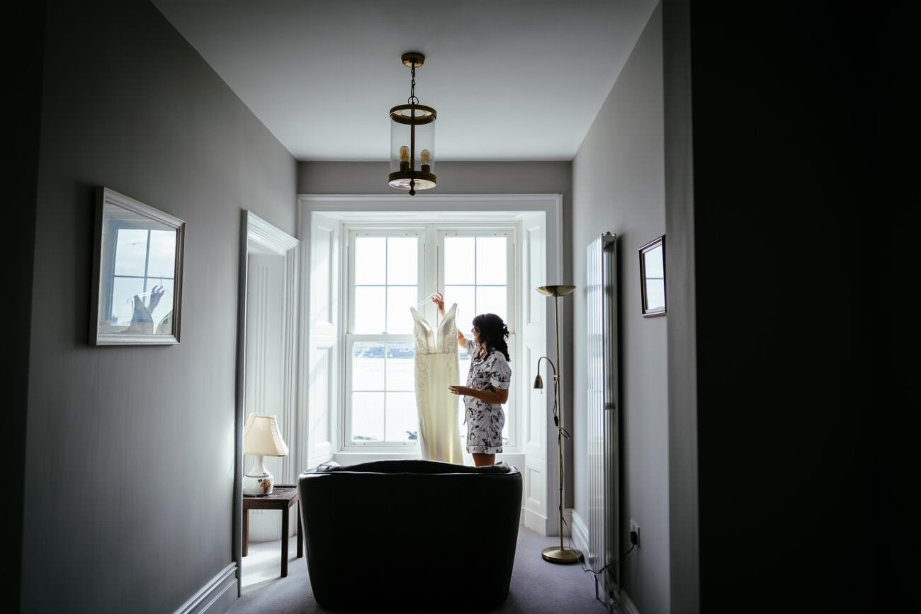 A bride standing in a hallway with her wedding dress at Trump International Hotel Doonbeg.
