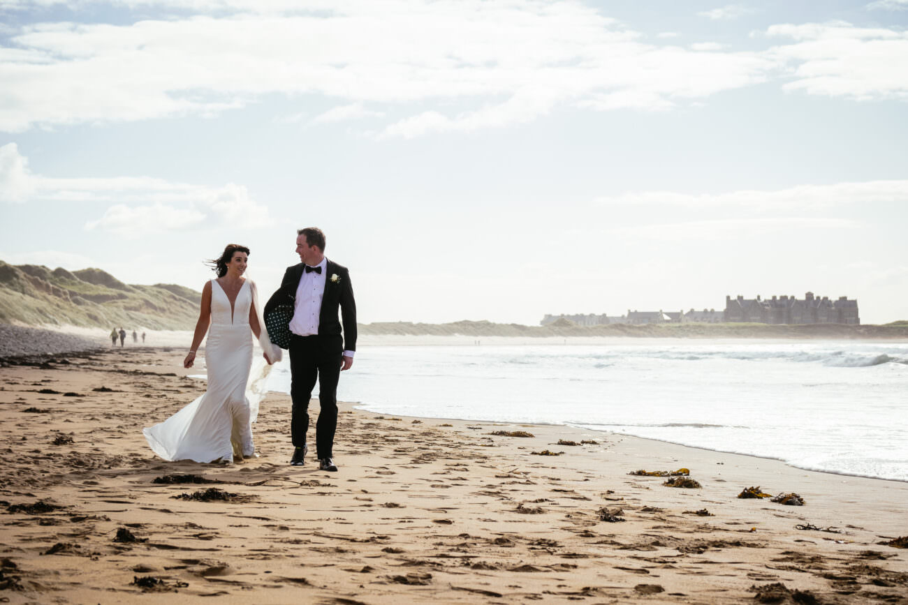 bride and groom walking along beach at their Trump International Hotel Doonbeg Wedding