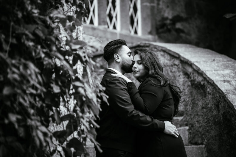 A black and white photo of an engaged couple embracing.