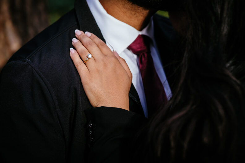 A man in a suit and tie is hugging a woman.