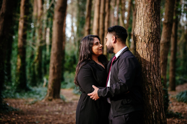 An indian couple embracing in the woods.